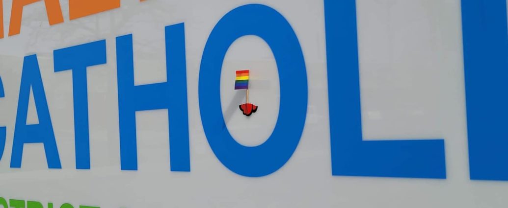 A small PRIDE flag taped to the HCDSB sign