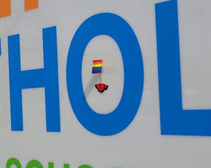 A small PRIDE flag taped to the HCDSB sign